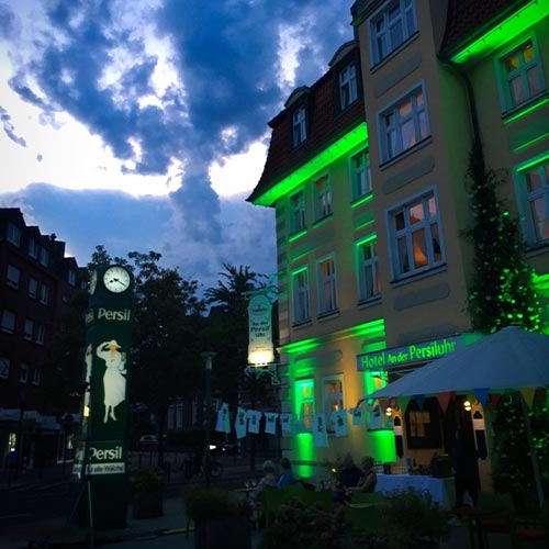 Das Hotel An der Persiluhr am Abend mit bunter Beleuchtung